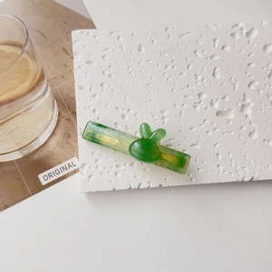 Détail de la pince à cheveux lapin en résine verte avec une texture effet jade
