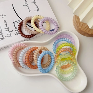 Translucent medium spiral hair ties in assorted pastel colors displayed on a ceramic tray