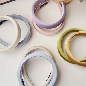 Top view of colorful thick sponge headbands with assorted satin finishes and handmade labels