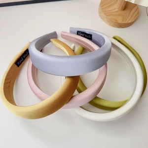 Close-up of five handmade padded sponge headbands in soft pastel colors and matte fabric