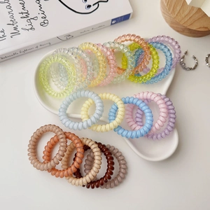 Close-up of colorful spiral telephone cord hair ties in a heart ceramic dish