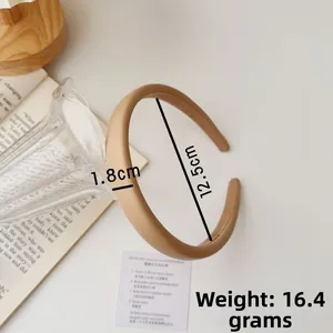 Detail showing the 1.8cm width of the light brown fabric headband in a cozy setting