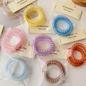 Close-up of colorful spiral telephone cord hair ties in individual card packaging