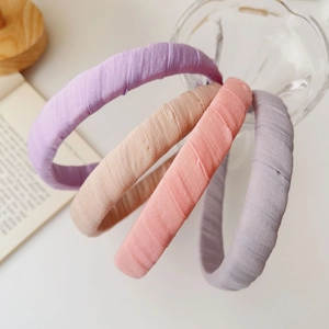Set of four pastel fabric-wrapped headbands in purple, beige, pink, and grey shades