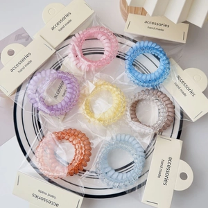 Pastel spiral hair ties set on a white ceramic plate with card packaging