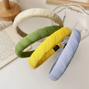 Detail view of multi-color striped fabric headbands showing handmade labels on glass