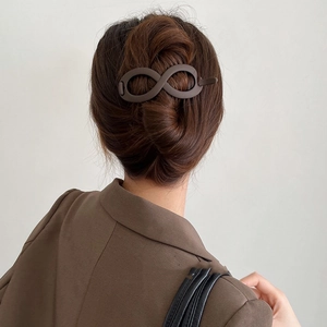 Elegant matte brown infinity hair clip shown worn in a sophisticated updo hairstyle