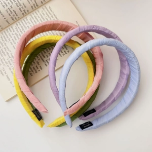 Detailed view of colorful fabric headbands with Hand made label on vintage book
