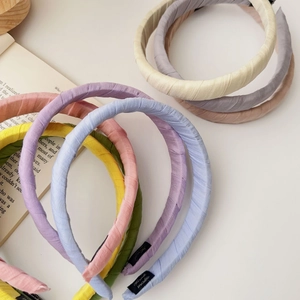 Detail of handmade fabric headband with cotton-linen texture and white handmade label