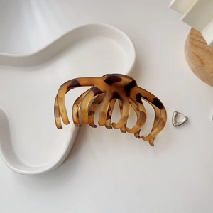 Detail of large tortoiseshell hair claw with octopus claw design on a white tray