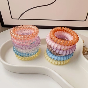 Macro shot of colorful spiral phone cord hair ties in a heart-shaped tray