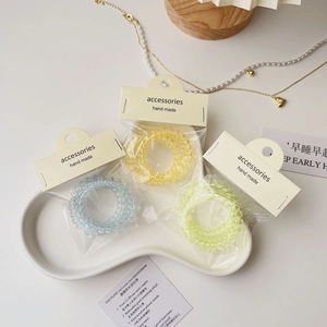 Gros plan de trois chouchous spirales colorés dans un emballage transparent avec étiquettes