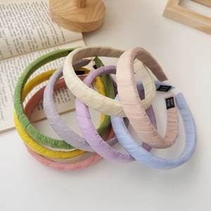 Detail of seven colorful fabric headbands with textured finish and small black woven labels
