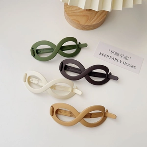 Macro view of four matte infinity hair clips in olive, brown, cream, and khaki colors