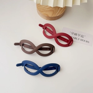 Detail of matte hair clips in red, brown, and blue with infinity figure eight design