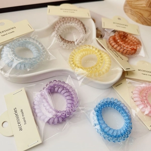 Detail of colorful spiral hair ties in individual packaging with display cards