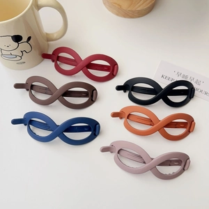 Set of six colorful matte infinity hair clips in elegant Morandi tones on a white table