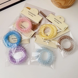 Set of colorful spiral telephone cord hair ties on minimalist card packaging