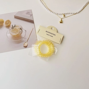 Vue détaillée de trois élastiques spirale jaunes dans un emballage de vente chic