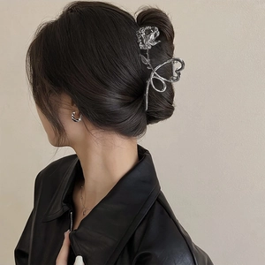 Detailed silver metallic rose hair claw clip worn on a French twist hairstyle