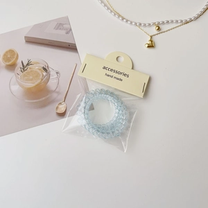 Gros plan d'un élastique spirale bleu clair dans son emballage artisanal décoratif