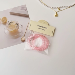 Gros plan d'élastiques spirales roses emballés avec une étiquette en papier fait main