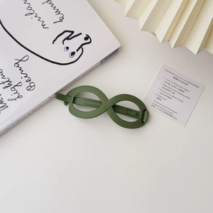 Detailed 45-degree view of an olive green infinity hair clip in matte resin finish
