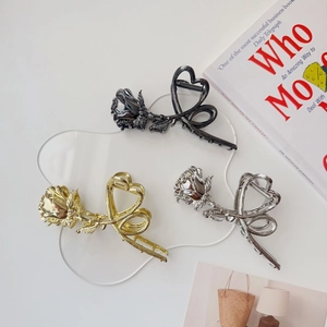 Detail shot of vintage metal rose hair claws in gold, silver, and black finish