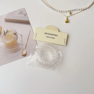 Gros plan sur élastiques cheveux spirale transparents avec emballage et accessoires