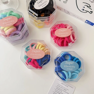 Close-up of five hexagon boxes containing high-elasticity colorful hair bands for kids