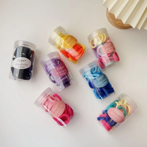 Detailed set of 7 colorful elastic hair ties in jars featuring ribbed texture fabric