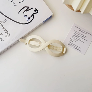 Macro detail of creamy matte finish 8-shaped hair clip with elegant minimalist texture