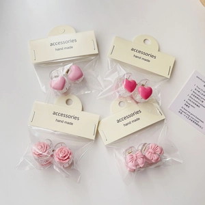 Close-up of pink camellia and bow hair clips with hand made accessories tags