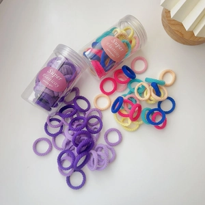 Detail of multi-color elastic hair ties set in a transparent cylinder jar
