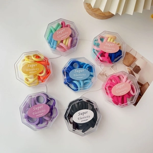 Detailed set of seven hexagonal boxes filled with colorful high-elastic hair ties for girls