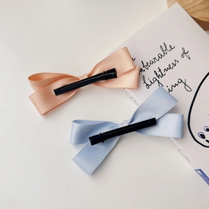 Dettaglio di fermagli per capelli a fiocco in raso rosa e azzurro con clip a coccodrillo