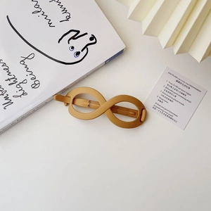 Detail view of mustard yellow infinite symbol hair clip with matte finish on elegant decor