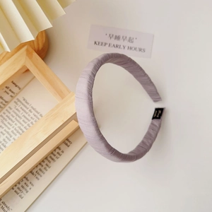 Detail of lavender fabric headband with pleated texture and soft wrap-around design