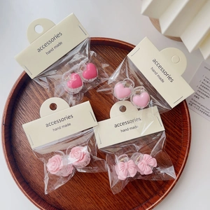 Pink heart and camellia flower hair claw clips in elegant retail display packaging