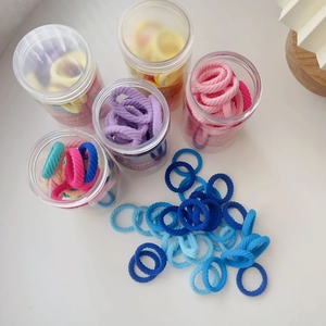 Macro view of high elasticity candy-colored knit hair ties in transparent storage jars