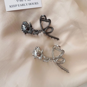 Detail of silver and gunmetal rose flower hair claws with elegant heart shaped metal lines