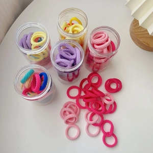 Macro shot of colorful high-elasticity hair ties in a transparent storage container