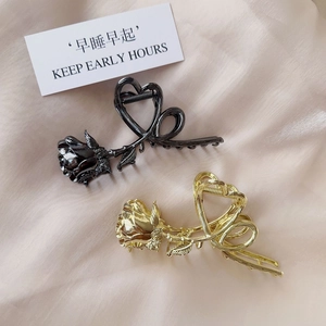 Detailed view of vintage metallic rose hair claws in shiny gold and gunmetal black finishes
