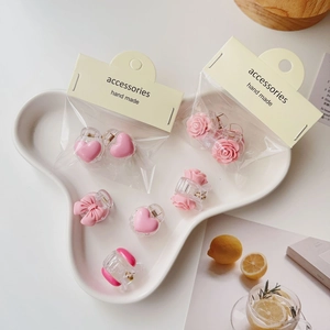 Pink resin hair claw clip set with bow and rose on white cloud tray accessory display