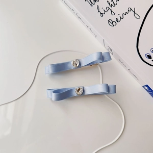 Dettaglio di fermagli per capelli a fiocco azzurro con cristallo a forma di cuore