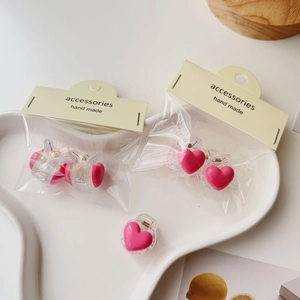 Detailed view of pink heart hair clips with metal spring on a ceramic tray