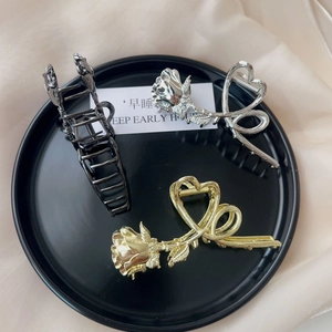 Detailed set of vintage metal rose hair claws in gold, silver and black on silk