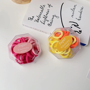 Detailed view of colorful high-elastic hair tie sets in clear hexagonal plastic boxes