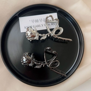 Detail of vintage metal rose hair claw clips with heart hollow design in silver and black