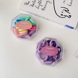 Close-up of colorful high elasticity ribbed hair ties in two hexagonal clear boxes
